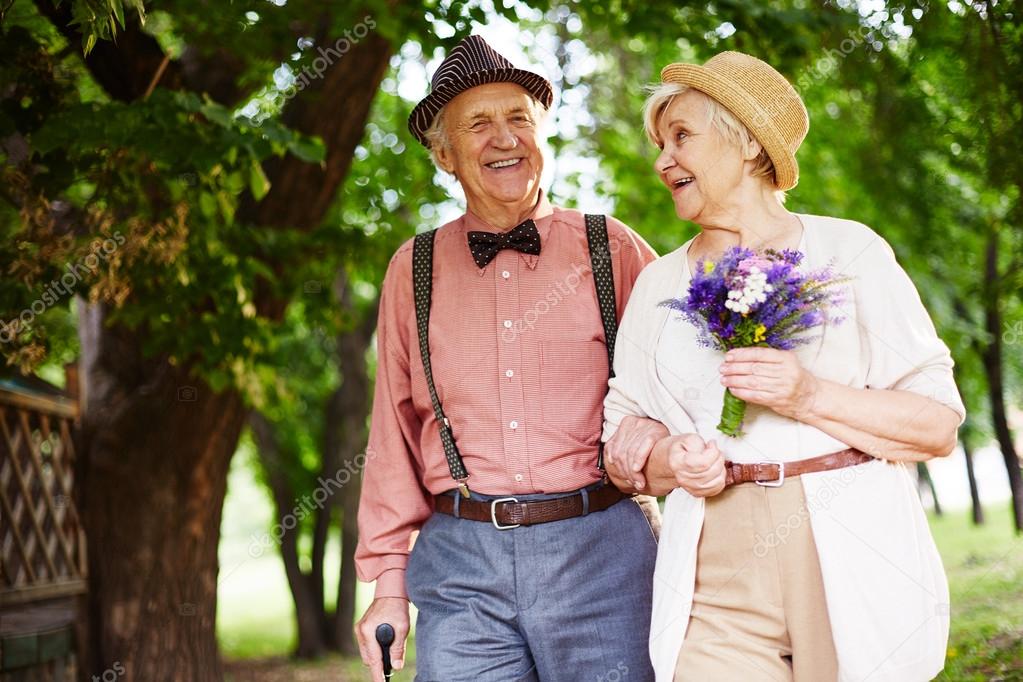 elderly couple walking in park