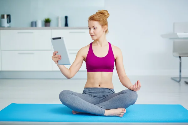 Mujer con touchpad en pose de loto — Foto de Stock