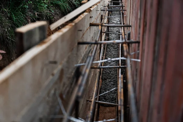 Beton dökmek ve bir bina ya da çit için sağlam bir temel oluşturmak için metal takviyeli kereste işi. İnşaat süreci.