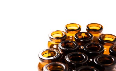 Birçok boş kahverengi cam tıbbi şişe beyaz arka planda izole edilmiştir. Tedavinin seyri tamamlandı. Kitle aşısı. Tabletler için kapasite. Yakın plan. Konteynır üretimi.