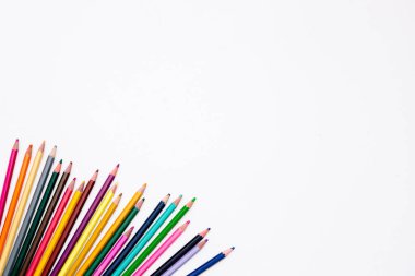 Köşedeki beyaz arka planda izole edilmiş renkli kalemler ve yazı için boş bir yer. Anaokulu, okul çocukları ve yetişkinlerin yaratıcı gelişimi ve eğitimi. Sanat kırtasiyesi.