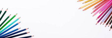 Renkli kalemlerin çerçevesi beyaz arkaplanda iki taraflı izole edilmiş ve yazı için boş bir yer var. Çocuk ve yetişkinlerin yaratıcı gelişimi ve eğitiminin sanat kırtasiyesiyle pankart.