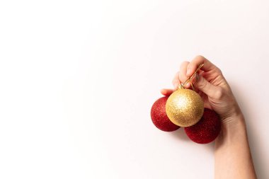 Beyaz arka planda izole edilmiş Noel ağacı oyuncakları. Yeni yıl parıltılı kırmızı ve altın renkli toplar. Moda tarzında yazılar yazan şenlikli bir pankart. Yakın plan..