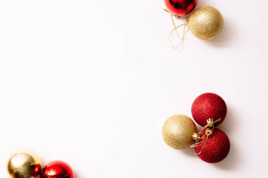 Beyaz arka planda izole edilmiş Noel ağacı oyuncakları. Yeni yıl sim topları kırmızı ve altın rengi. Moda tarzında yazılar yazan şenlikli bir pankart. Yakın plan..