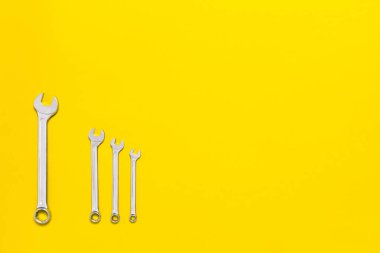 Farklı boyutlarda dört metal anahtar fotokopi alanı olan kırmızı bir arka planda izole edilmiş. Patron ve çalışan, yaşlı ve genç, büyük ve küçük, ebeveyn ve çocuk arasındaki fark kavramsal fikir.