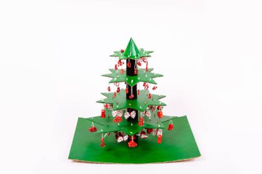 Adım adım Noel ağacı yapmayı öğretiyorum. Yapıştırıcı kullanarak makarnayla süslenmiş yıldız katlarını kağıt havlulardan tüp ve karton bir standın üzerine yapıştırıcı ile birbirine bağlıyoruz..