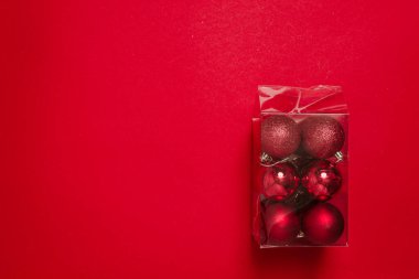 Zengin Noel ağacı topları şeffaf bir plastik kutuda paketlenir. Noel tatiline hazırlanıyorum. Noel süsleri ve oyuncakları satan bir mağazanın afişi. Tatil sonrası temizlik.