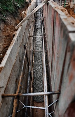 Beton dökmek ve bir bina ya da çit için sağlam bir temel oluşturmak için metal takviyeli kereste işi. İnşaat süreci.