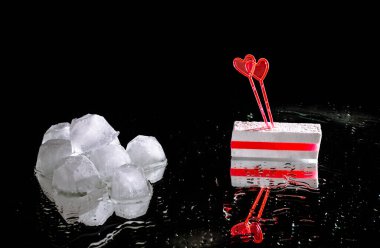 Kırmızı marmelatlı beyaz şeker ve iki kalp şeklinde şiş. Aynalı siyah bir zeminde buzu eritmek. Belarus halkının, çevik kuvvet polislerinin şiddetine karşı muhalefeti