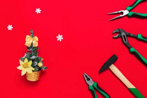 A set of quality green building tools to repair a car or house and Christmas tree on a red background. Do it yourself instruments. Banner for a New year advertise construction shop with copy space.