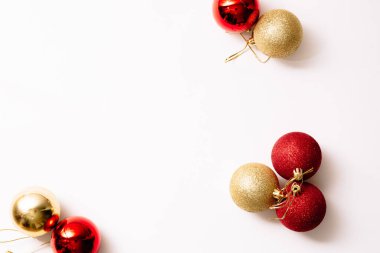 Beyaz arka planda izole edilmiş Noel ağacı oyuncakları. Yeni yıl sim topları kırmızı ve altın rengi. Moda tarzında yazılar yazan şenlikli bir pankart. Yakın plan..