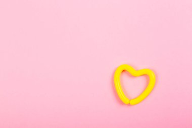 Pembe arka planda sarı kalp ve fotokopi alanı. İlişkiler, sağlık, tıp, yaşam tarzı ya da spor konularında reklamcılık planı. 14 Şubat Sevgililer Günün kutlu olsun. Âşık ol. Minimalizm.