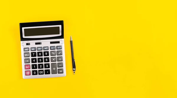 Duży Srebrny Kalkulator Szarymi Czarnymi Przyciskami Oraz Czarny Długopis Żółtym — Zdjęcie stockowe