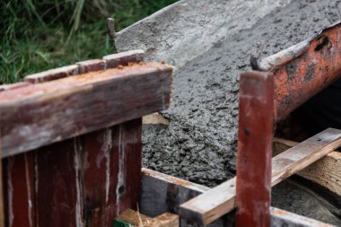 Beton karıştırıcı, beton karıştırıcıyı bir paraşütten bir kereste formuna boşaltıyor ve bir bina veya çit için sağlam bir temel oluşturmak için metal takviyesi sağlıyor. İnşaat süreci.