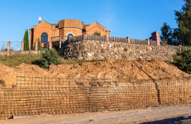 Bir istinat duvarı veya karşı kale inşaatı, formalite, takviye, beton dökme hazırlığı, inşaat alanı. Bölgenin gelişimi. Toprak kaymasına karşı önleyici tedbirler.