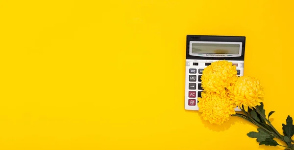 Büyük gümüş hesap makinesi ve çiçek buketi sarı arka planda fotokopi alanı ile birlikte. İş yerindeki kadınlar gününde iş tatili ve tebrik kartı kavramı. 8 Mart. Profesyonel muhasebeci günü.