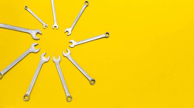 Sarı arka planda güneş şeklindeki anahtarlar farklı boyutlarda. Aletli güneşli afiş. Fotokopi endüstriyel konsepti olan kartpostal. Mekanik bir alet. Kartvizit. Enstrümanlar dükkan kurdu.