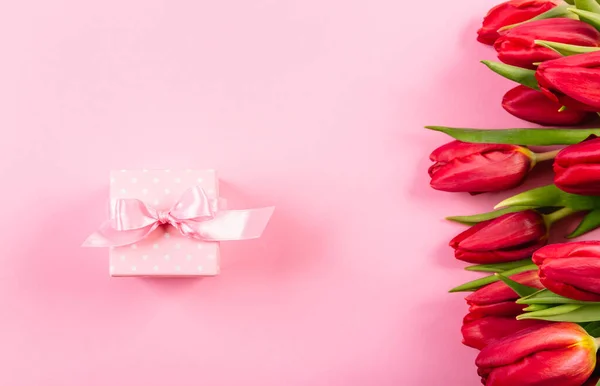 Подарункова Коробка Рожевою Стрічкою Білих Крапках Фоні Букета Червоних Тюльпанів — стокове фото