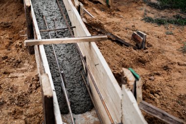 Beton dökmek ve bir bina ya da çit için sağlam bir temel oluşturmak için metal takviyeli kereste işi. İnşaat süreci.