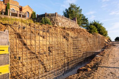 Bir istinat duvarı veya karşı kale inşaatı, formalite, takviye, beton dökme hazırlığı, inşaat alanı. Bölgenin gelişimi. Toprak kaymasına karşı önleyici tedbirler.