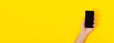 Sarı arkaplanda telefonu olan afiş ve kopyalama alanı, mesaj için boş alan. Tasarım düzeni. İnternette reklam kursları. Yüksek hızlı internet. Yeni akıllı alet. Modern teknolojiler. Telefon çalıyor..