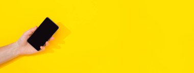 Sarı arkaplanda telefonu olan afiş ve kopyalama alanı, mesaj için boş alan. Tasarım düzeni. İnternette reklam kursları. Yüksek hızlı internet. Yeni akıllı alet. Modern teknolojiler. Telefon çalıyor..