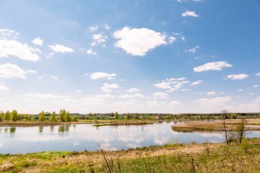 Güzel yaz manzarası. Uzakta bir nehir ve köy manzarası. Eğlence alanı olarak. Güneşli sıcak hava. Düz arazi. Belarus Gölü. Doğal yerlere git. Duvar kağıdı doğal tasarımı.