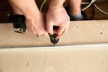 Elektrikli tornavida. Marangoz kontrplak üzerinde el aletleriyle çalışıyor. Yan görüntüyü yakından çek. Metal kalası tamir ediyorum. Uzayı kopyala İşçi bayramı. Akü aleti. Çalışma kuralları ve güvenlik önlemleri.