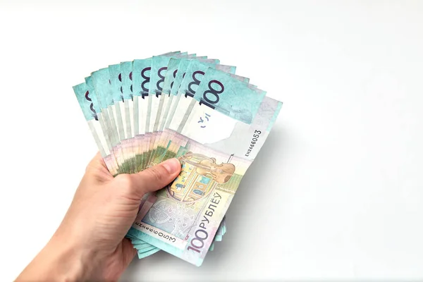Beyaz arka planda bir yığın para izole edilmiş. 100 Belarus Rublesi 'nin banknotu. Asgari ücret. Yaşayan maaş bütçesi. Yakın plan. Çevrimdışı ödemeler. Nakit ödeme. Finansal kredi. Enflasyon.