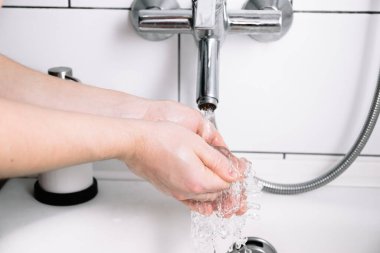 Erkek yıkama sabunlu elleri banyoda. Kişisel hijyen prosedürü. Sağlık hizmetleri. Saf saf musluk suyu. Yakın plan. Beyaz oda. Temiz kollar. Krom musluğu.