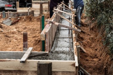 Beton dökmek ve bir bina ya da çit için sağlam bir temel oluşturmak için metal takviyeli kereste işi. İnşaat süreci.