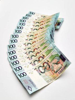 Beyaz arka planda izole edilmiş bir yığın para. 100 Belarus Rublesi 'nin banknotu. Asgari ücret. Yaşayan maaş bütçesi. Yakın plan. Çevrimdışı nakit ödemeler. Finansal kredi. Enflasyon. Kriz tasarrufu.