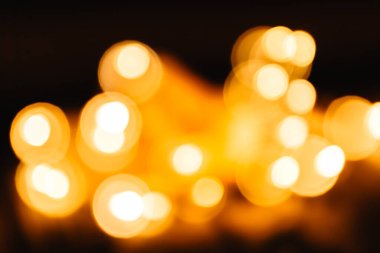 Siyah arka planda sarı, parlak, büyük bir bokeh ışığı. Şenlikli bir arka plan için soyut mavi dokular. Zengin altın bayrak.