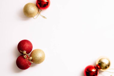 Beyaz arka planda izole edilmiş Noel ağacı oyuncakları. Yeni yıl sim topları kırmızı ve altın rengi. Moda tarzında yazılar yazan şenlikli bir pankart. Yakın plan..
