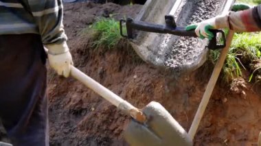 Beton karıştırıcı kamyon oluğu. Sıvı, beton karışımını inşaat demirine akıtıyor. Temeli de işçiyle birlikte işliyor. İcra duvarı. Çit. Yakın plan. Tank taşıyorum. İnşa süreci.