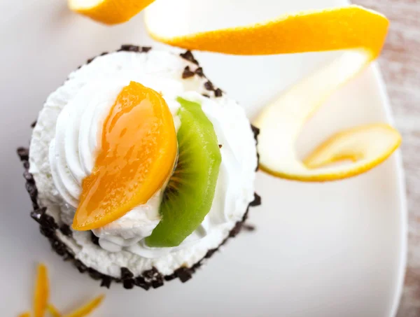 Cake met room en segmenten van vruchten — Stockfoto