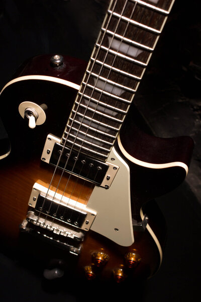 Sunburst electric guitar close-up view in the dark
