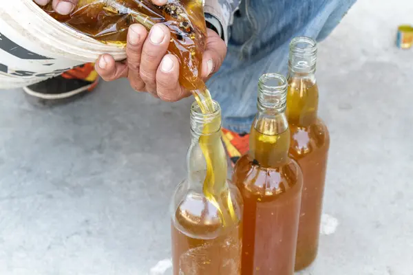 Man pouring honey bottle