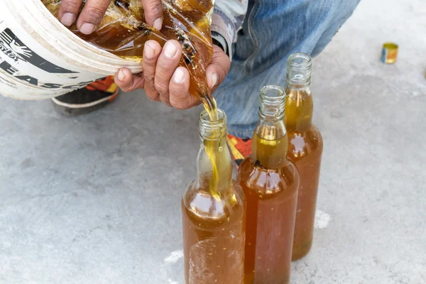 Man pouring honey bottle