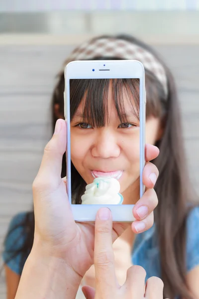 Smartphone přijetí dívku jíst zmrzlinu — Stock fotografie