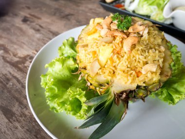 Ananaslı pilav ve ananaslı meyve. Restoranda beyaz tabakta..