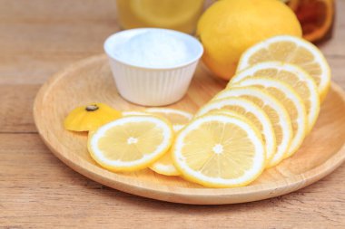 Tahta tabakta limon dilimi ve tuz ve fotokopi alanı olan ahşap masa..