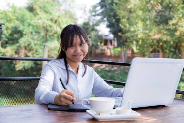 Dizüstü bilgisayarında fare kalemiyle çalışan serbest çalışan bir genç. Seçici odak ve yumuşak işaret fişeği filtresiName.