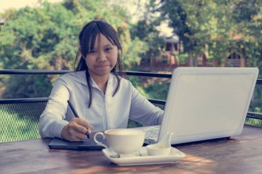 Dizüstü bilgisayarında fare kalemiyle çalışan serbest çalışan bir genç. Seçici odak ve yumuşak işaret fişeği filtresiName.
