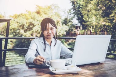 Dizüstü bilgisayarında fare kalemiyle çalışan serbest çalışan bir genç. Seçici odak ve yumuşak işaret fişeği filtresiName.