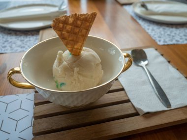 Vanilyalı dondurma. Lokantadaki ahşap masada bir kepçe lüks..