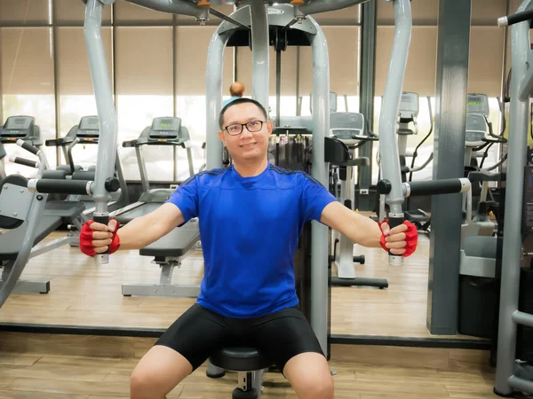 Asia man middle aged training arm equipment in the gym for strength, weight loss.
