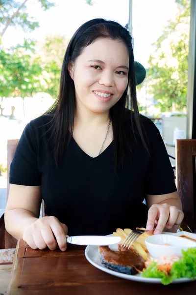 魚サーモン ステーキを食べる女子高生 — ストック写真