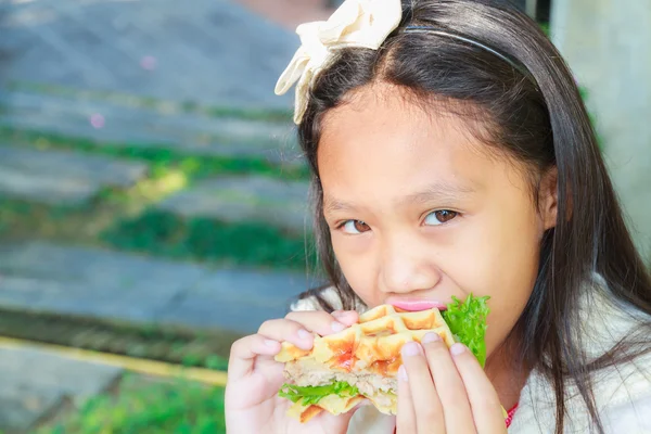 Kind meisje eten wafels varkensvlees — Stockfoto