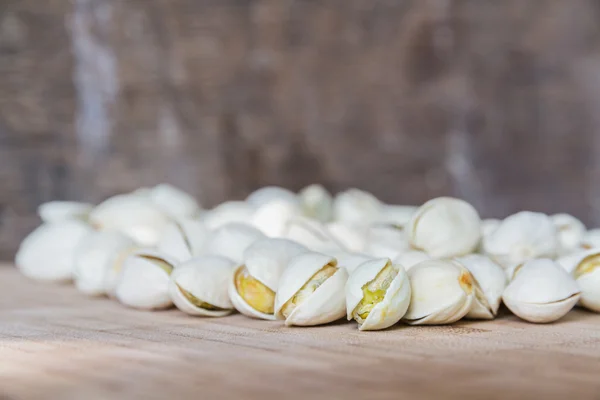 Pistachos sobre mesa de madera . — Foto de Stock